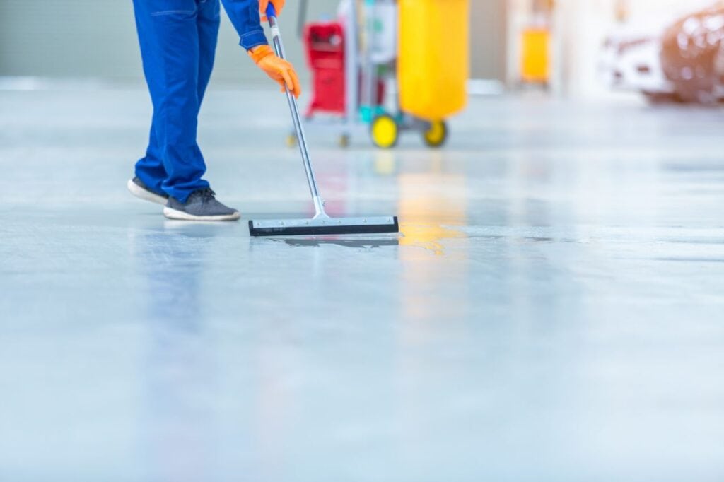 car mechanic repair service center cleaning using mops roll water from epoxy floor car repair service center