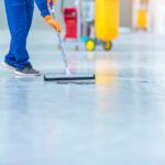 car mechanic repair service center cleaning using mops roll water from epoxy floor car repair service center