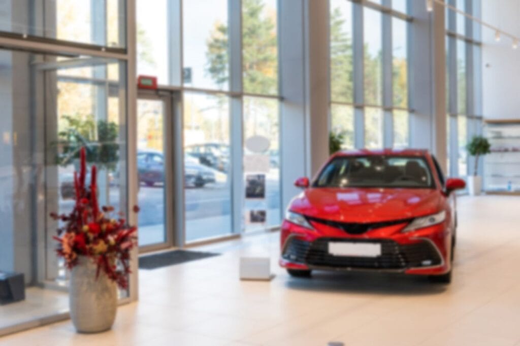 spacious car dealership with expensive red car photo with blur